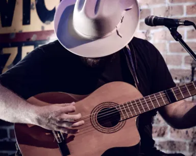 Cowboy hat playing country acoustic guitar