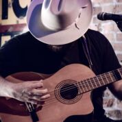 Cowboy hat playing country acoustic guitar